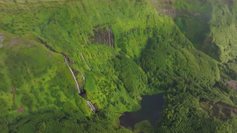 Panoramic-view-of-Poço-Ribeira-do-Ferreiro-waterfall-in-lush-green-vegetation,-aerial