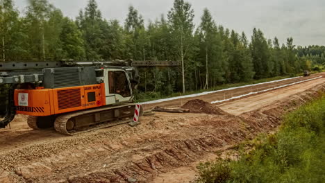 Building-of-a-forest-dirt-road-by-workers-with-concrete-pressing-machine-time-lapse