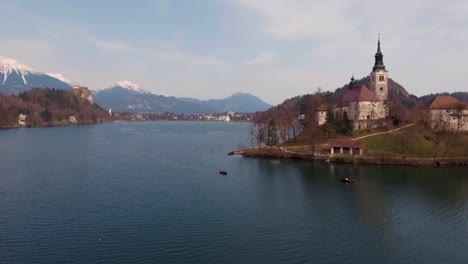 Drohne-über-Wasser-Nach-Vorne,-Niedrige-Flugansicht,-Bled-See-Insel-Kirche-Im-Winter