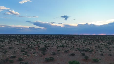 Aufsteigender-Drohnenflug-über-Dem-Halbtrockenen-Kalahari-Buschland,-Berge-Im-Hintergrund