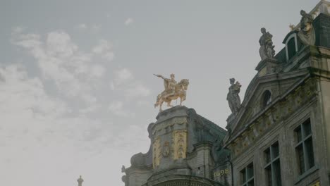 Gold-Statues-on-Rooftop-of-Guildhall-Building,-Cloudy-Sky,-Grote-Markt
