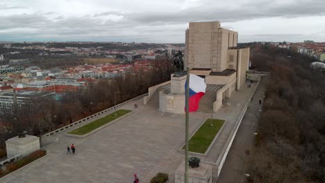 Prague,-Czech-Republic,-Aerial-View-of-Waving-Flag-and-National-Monument-on-Vitkov-Hill-WIth-Jan-Zizka-Equestiran-Statue