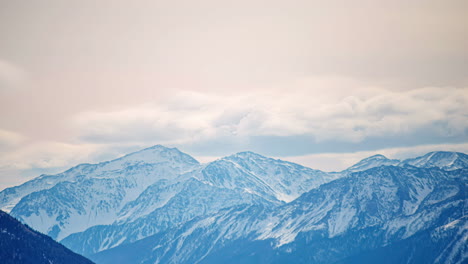 Cordillera-Cubierta-De-Nieve-Con-Nubes-Formándose-En-Un-Timelapse-En-Movimiento