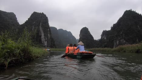 Row-boats-Ninh-Binh-Vietnam,-tourists-rowing-in-timelapse