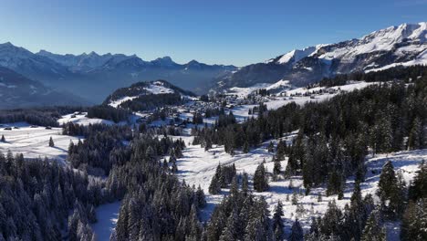 Anflug-Aus-Der-Luft,-Der-Das-Dorf-Amden-Zeigt,-Umgeben-Von-Schneebedeckten-Bergen-In-Der-Schweiz
