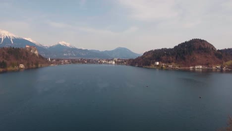 Drohne-über-Wasser-Nach-Vorne,-Niedrige-Flugansicht,-Bled-See-Insel-Kirche-Im-Winter