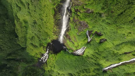 Big-waterfall-in-middle-lush-green-jungle-at-Flores-island-Azores---Drone-shot