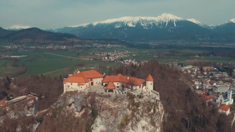 Drone-forward-flying-over-Bled-lake-castle-in-winter