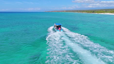 Navigating-tourist-boat-with-tourists-along-Bahia-de-las-Aguilas-coastline-and-shoreline-in-Dominican-Republic