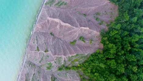 A-4K-drone-shot-over-the-large-clay-formations-of-Chimney-Bluffs-State-Park,-on-the-water's-edge-of-Lake-Ontario,-in-the-town-of-Huron,-New-York