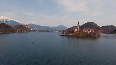 Langsame-Drohne-über-Dem-Wasser,-Vorwärts,-Niedrige-Flugansicht,-Bled-See-Insel-Kirche-Im-Winter