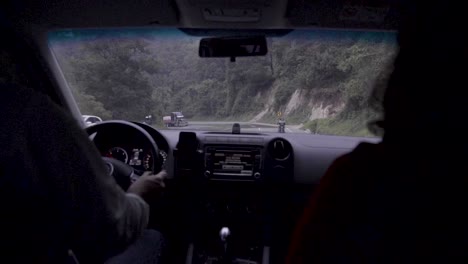 Couple-driving-on-a-curvy-road-in-slow-motion,-day-time
