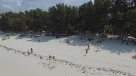Drone-shot-of-people-enjoying-the-beach-of-Paje-in-Zanzibar,-Tanzania