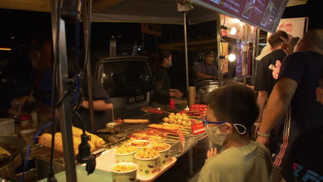 Woman-Serving-Food,-Night-Market,-Kuala-Lumpur,-Malaysia