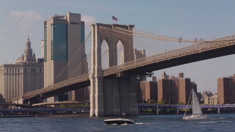 Segelboot-Und-Motorboot-Fahren-Auf-Dem-Fluss-Unterhalb-Der-Brooklyn-Bridge-Und-Dem-Verizon-Gebäude-Im-Hintergrund---New-York,-Amerika