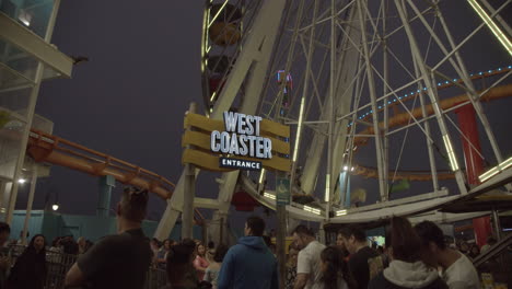 It's-summer-time-at-night-in-Santa-Monica's-Pacific-Park-with-Rollercoaster-and-Ferris-Wheel-in-slow-motion