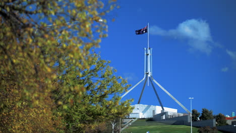 Vista-De-La-Casa-Del-Parlamento-Australiano-Con-Bandera-Ondeando-Alto