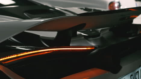 Stylish-spoiler-on-rear-end-of-white-McLaren-sports-car,-tail-light,-close-up