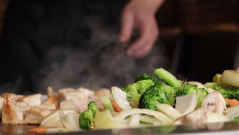 Close-up-of-Japanese-Teppanyaki-chef-grilling-vegetables-on-a-flat-top-grill