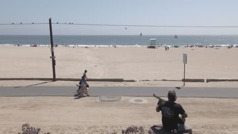 Mann-Spielt-Gitarre-Am-Strand-In-Kalifornien-Mit-Sand-Und-Meer-Im-Hintergrund