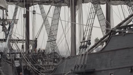 Galleon-Andalucia-replica-ship-detail-tilt-shot-of-with-people-working-while-docked-in-Valencia-in-slow-motion-60fps