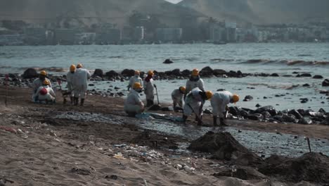 Oil-workers-clean-up-contaminated-beach