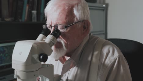 Männlicher-Wissenschaftler,-Der-In-Ein-Mikroskop-Schaut