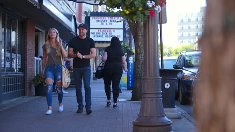 Full-Shot-of-Couple-in-Mid-Twenties-Laughing-Together-as-They-Walk-Down-Whyte-ave-in-Edmonton,-Alberta