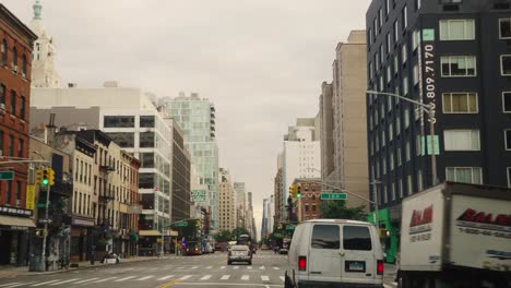 Pov-drive-on-busy-street-with-bus-of-New-York-in-neighborhood-during-cloudy-day