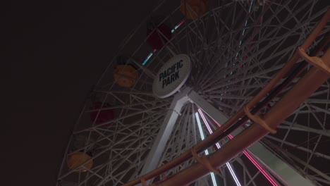 Nice-perspective-shot-of-the-famous-pacific-park-ferris-wheel-in-santa-monica,-ca-at-night-in-slow-motion