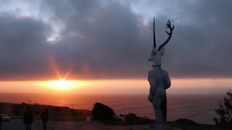 Deer-surfer-sculpture-at-Nazaré-beach,-Portugal