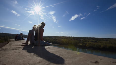 A-Slow-Motion-Wide-Dolly-Shot-of-a-Couple-Sitting-and-Talking-on-Cliffs-Edge-at-"End-of-The-World"-in-Edmonton,-Alberta
