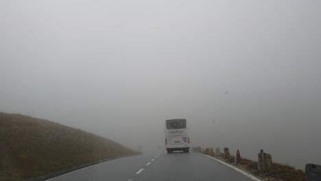 Driving-after-a-bus,-through-a-foggy-spot-on-Grossglockner-Alpine-road-in-Austria