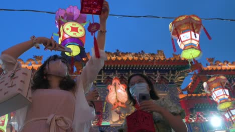 Visitors-hold-up-lanterns,-which-symbolize-prosperity-and-good-fortune,-at-the-Wong-Tai-Sin-temple-to-celebrate-the-Mid-Autumn-Festival,-also-called-Mooncake-Festival