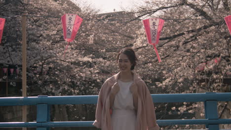 Beautiful-Model-standing-on-a-bridge-in-japan-with-sakura-trees