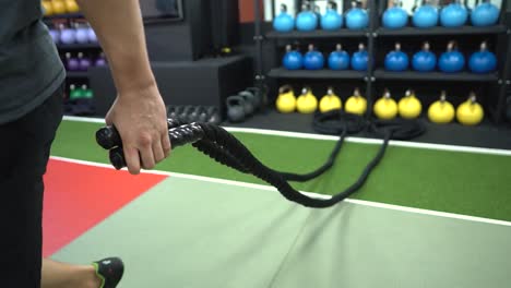 A-man-is-pulling-out-the-battle-rope-for-his-exercise-in-the-gym