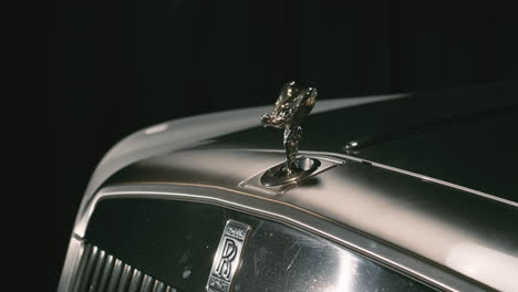 Rolls-Royce-hood-ornament-Spirit-of-Ecstasy-popping-out-from-cover,-iconic-brand