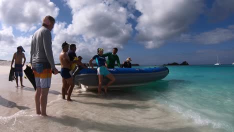 Ein-Passagier-Bereitet-Sich-Darauf-Vor,-An-Einem-Strand-Mit-Weißem-Sand-Und-Türkisfarbenem-Wasser-Der-Galapagos-Inseln-An-Bord-Des-Bootes-Zu-Gehen