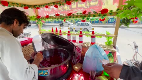 -Street-Vendor-Pouring-Watermelon-On-Roadside-Stall-In-Saddar-For-Customer