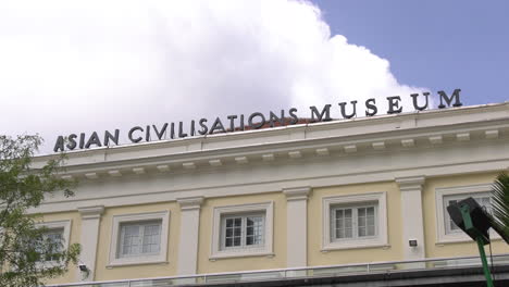 Still-shot-of-the-ASIAN-CIVILISATIONS-MUSEUM-title-on-the-roof-of-the-building-with-thick-clouds-moving-in-a-clear-blue-afternoon-sky