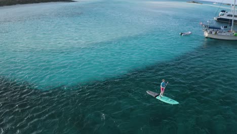 Tourist-Paddleboard-on-Tropical-Island-Ocean-Waters-in-the-Bahamas,-Aerial