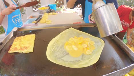 Thai-women-bake-pancakes---roti-with-bananas,-eggs-and-butter