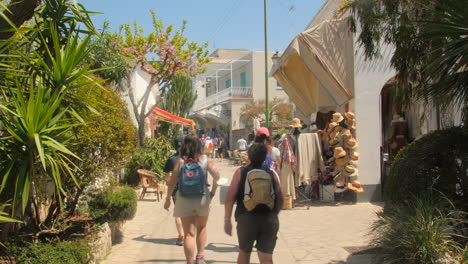 Pan-shot-of-tourists-walking-on-the-shopping-street-of-Anacapri,-Italy-on-a-bright-sunny-day
