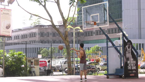 Un-Niño-Lanzando-Una-Pelota-A-La-Red-En-Una-Cancha-De-Baloncesto-Pública-En-Singapur.