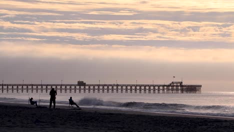 People-fishing-beneath-Apache-Pier-early-in-the-morning-Myrtle-Beach,-SC