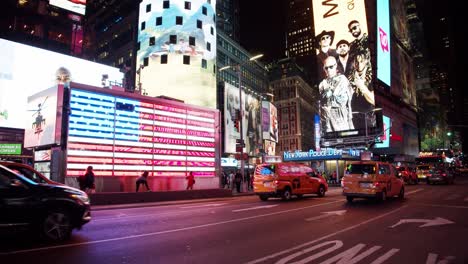 Eine-US-Flagge-Aus-LED-Licht-Leuchtet-Zwischen-New-Yorker-Taxis-Auf-Dem-Time-Square