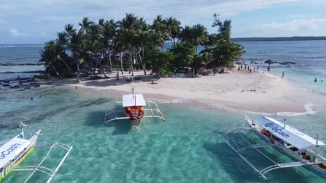Guyam-Island---Siargao,-flying-low-over-Island-hopping-tour-Boats-towards-girl-in-swimsuit