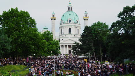 Una-Toma-Amplia-Y-Dramática-Muestra-A-Miles-De-Personas-Manifestándose-Emocionalmente-Frente-A-La-Karlskirche-En-El-Corazón-De-Viena,-La-Capital-De-Austria.