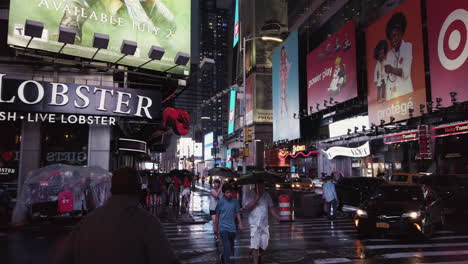Busy-New-York-Broadway-street-avenue-during-night-with-bright-lights-and-billboards,-just-after-a-rainstorm-has-passed,-people-crossing-the-street