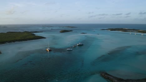 Boats-Anchored-in-over-Tropical-Waters-in-Grand-Bahama,-Aerial-Drone